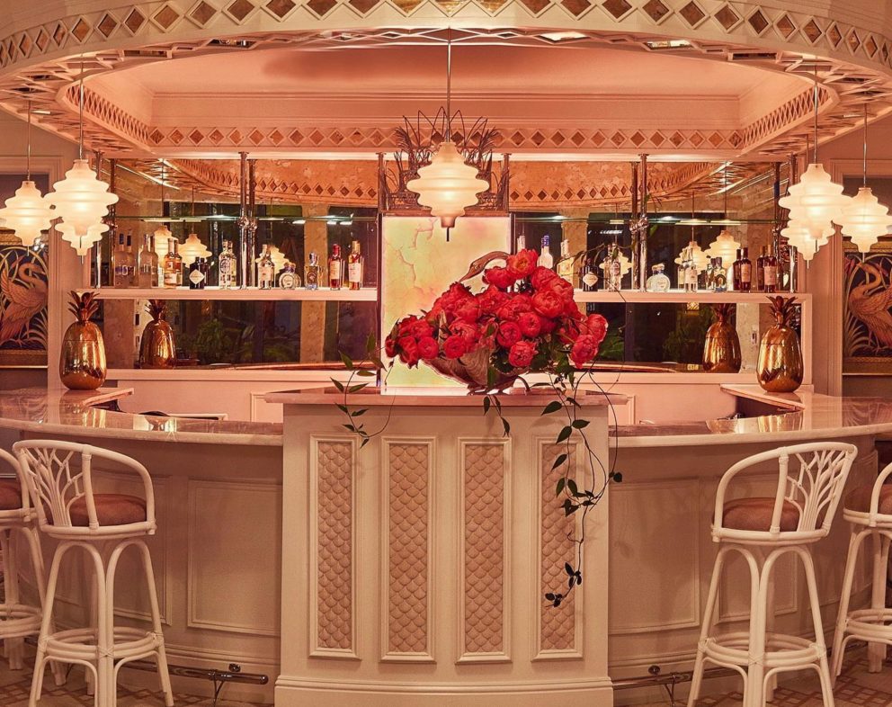 Bar with a pink top, white chairs, and other pink accents.