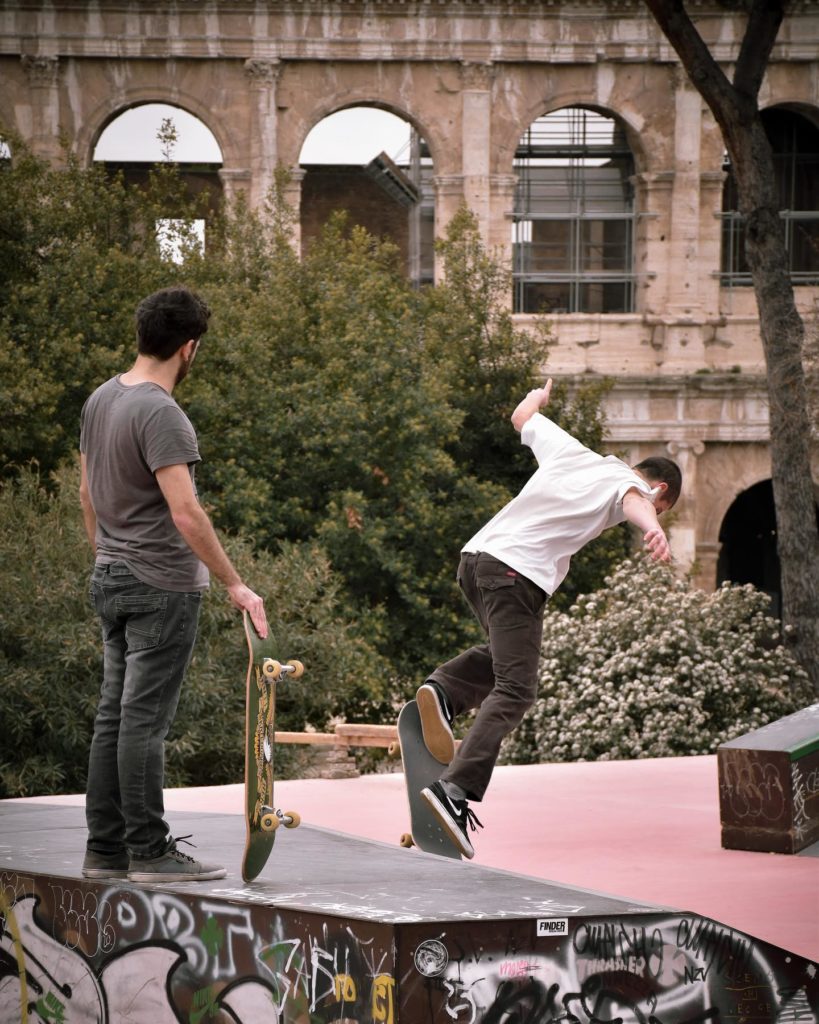Two men skateboarding in a skate park in Rome.