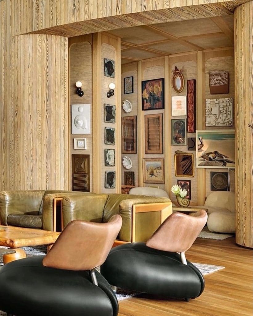 Wooden paneled room with different chairs and art pieces on the wall.