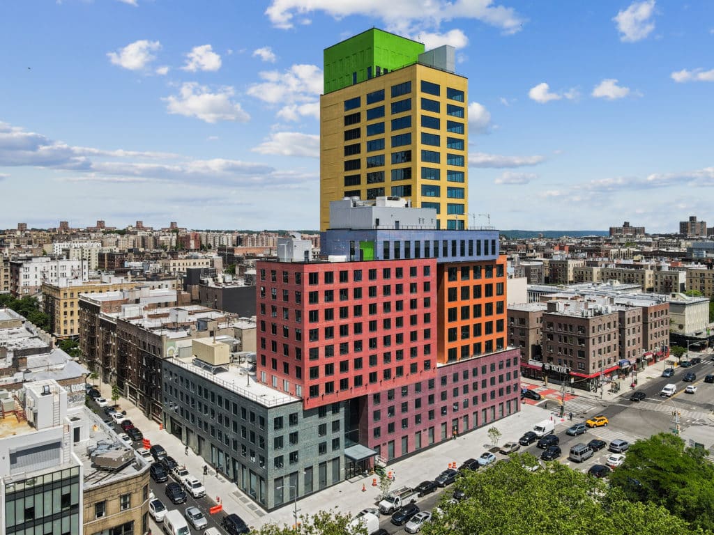 Large building with different colored floors. There is red, orange, blue, yellow, and bright green on the outside of the building.