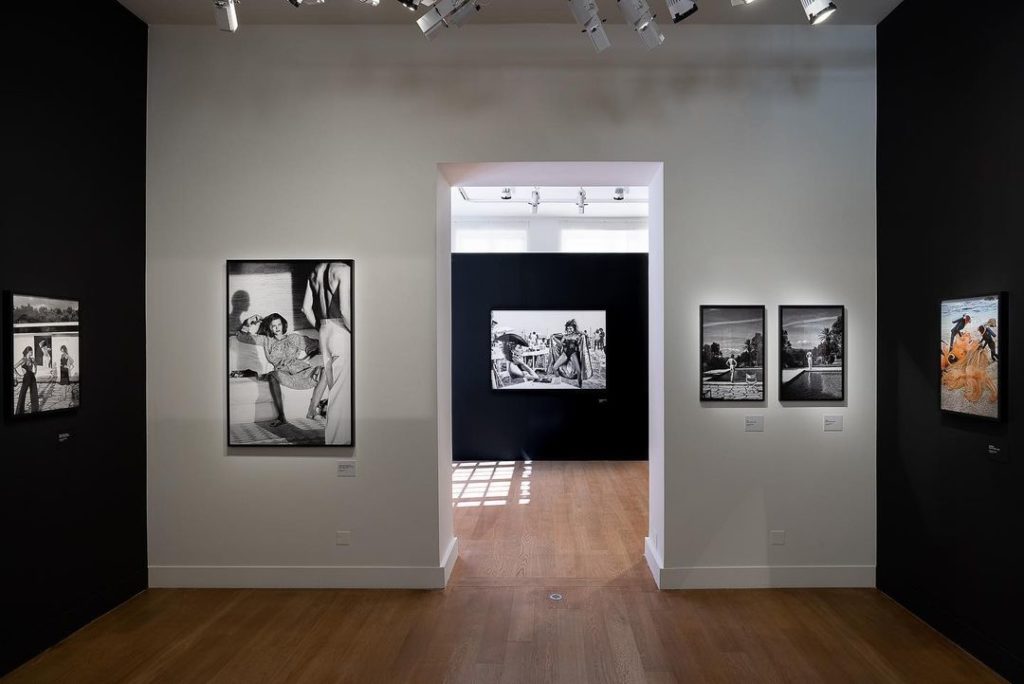 Inside of an art museum with black and white photographs hanging from the wall.