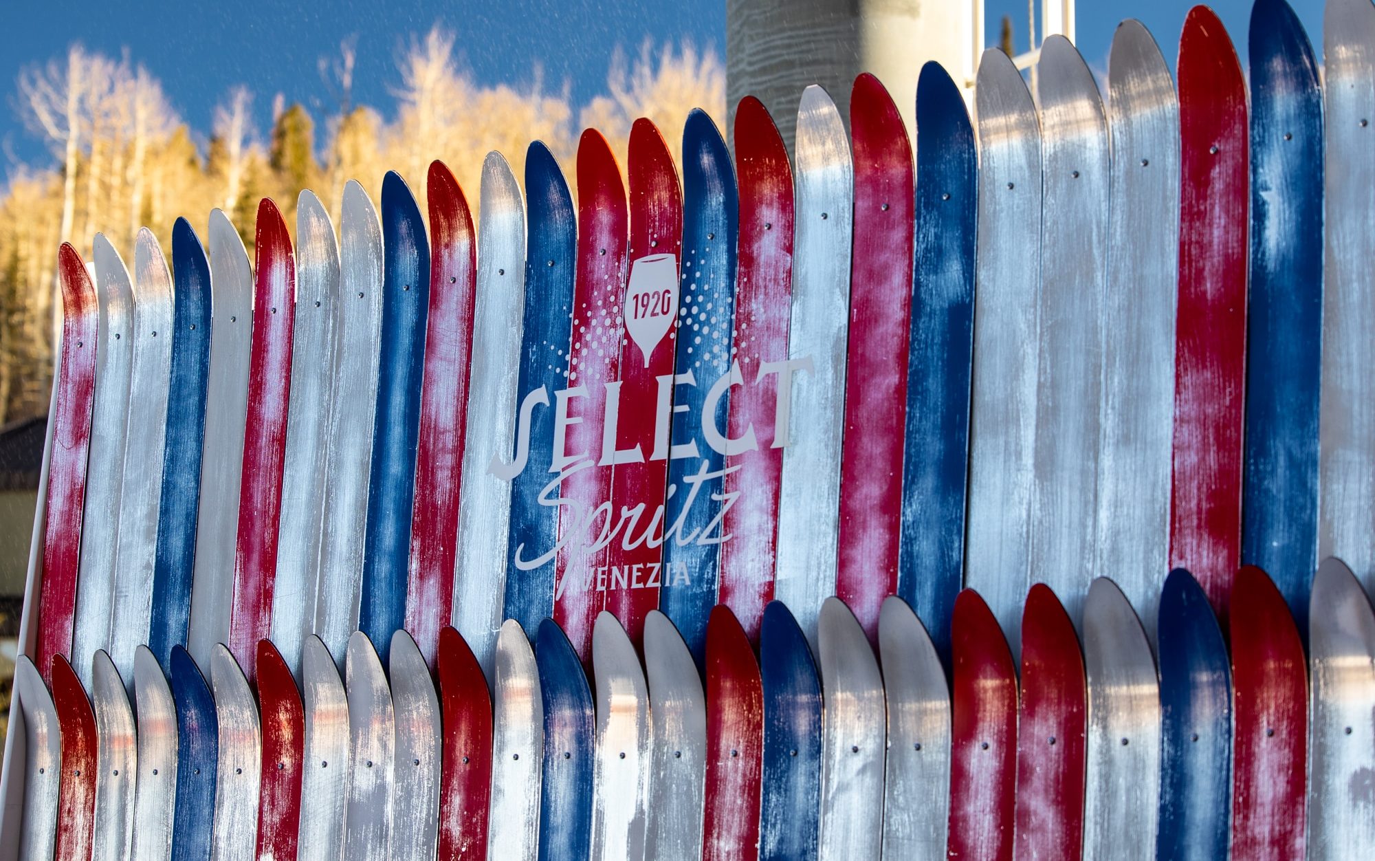 Red, white, and blue skis forming a sign for Select Aperitivo Spritz.