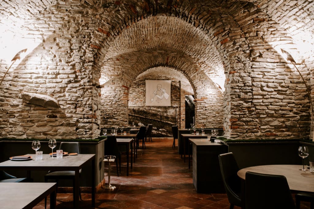 Restaurant in Italy with large stone walls and archways.